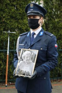 Policjanta w nowym umundurowaniu galowym z fotografią zmarłej