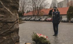 Komendant Kuster oddaje honor przed Krzyżem Martyrologicznym i Obeliskiem na terenie KWP w  Krakowie