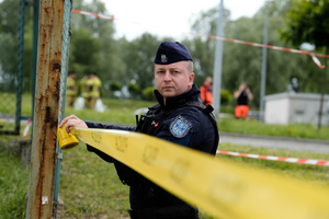 Policjant rozciągający policyjna żółtą taśmę zabezpieczającą