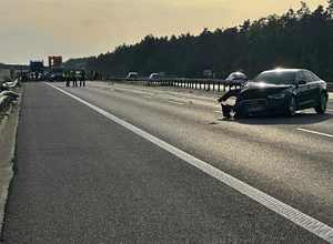 czarne audi z rozbitym prawym narożem stojące w poprzek autostrady