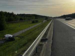 Przewrócony dostawczak na drodze technicznej wzdłuż autostrady