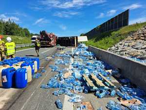 Rozsypane butelki plastikowe z woda na poboczu autostrady