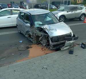 Zniszczony samochód osobowy suzuki stojący w poprzek drogi