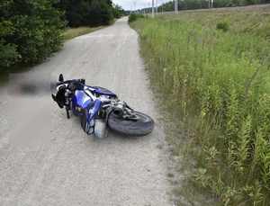 przewrócony motocykl na drodze szutrowej