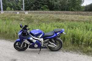 Motocykl Yamaha ustawiony na podnóżce bocznej stojący na drodze szutrowej