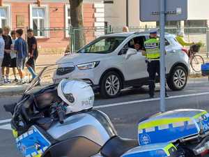 Policjant ruchu drogowego rozdający kierowcom ulotki