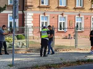 Policjant ruchu drogowego rozdający uczniom elementy odblaskowe