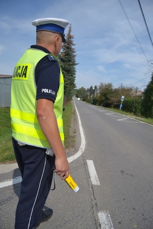 Policjant Wydziału Ruchu Drogowego trzymający w dłoni alkomat