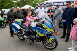 Motocykl WRD na którym siedzi dziecko. Obok stoi policjant WRD