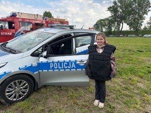 Dziewczynka ubrana w policyjną kamizelkę przeciwuderzeniową