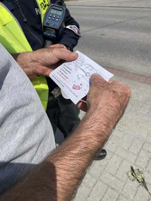 Kierowca trzymający ulotkę otrzymaną od przedszkolaków