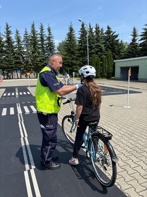 Policjant WRD poprawiający kask rowerzyście