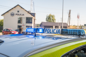 Zdjęcie świateł radiowozu policyjnego na tle wojnickiego komisariatu.