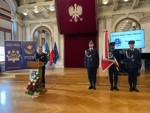 Komendant Wojewódzki wygłaszający przemówienie oraz policjanci wraz ze sztandarem.