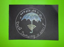 Na zielonym tle czarna prostokątna kartka. Białym kolorem cienka linia w kształcie okręgu. wewnątrz otwarty parasol chroniący przed deszczem i plikami komputerowymi (ikonki internetowe). Na rączce parasola symbol Wi-fi. Poniżej hasło &amp;quot;Bądż Bezpieczny w sieci&amp;quot;