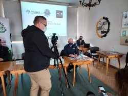 Konferencja z udziałem umundurowanego policjanta