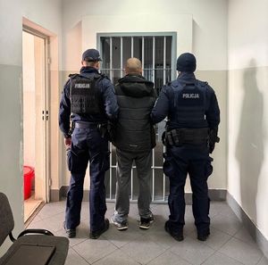 Policjanci doprowadzający zatrzymanego mężczyznę do PDOZ