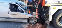 Zbliżenie na wbity samochód pod ciężarówkę straży pożarnej. Widok od strony prawej.