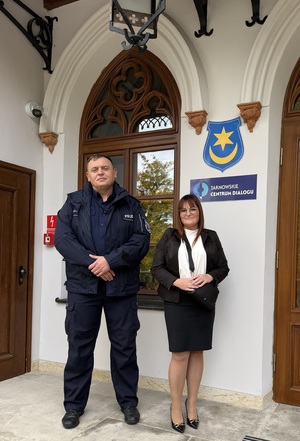 umundurowany policjant i nieumundurowana policjanta - psycholog policyjny pod budynkiem Urzędu Miasta w Tarnowie