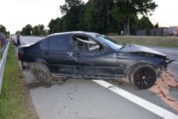 prawy bok zniszczonego samochodu marki BMW, samochód stoi w poprzek drogi