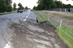 miejsce uderzenia samochodu w liny ograniczające pas jezdni, na poboczu po prawej stronie widoczny plastikowy element zderzaka