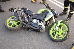 motocykl czarno-zielony leżący na jezdni