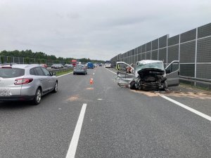 Ogólne miejsce wypadku, po prawej zniszczony samochód dostawczy, po lewej samochody osobowe jadące drugim pasem ruchu