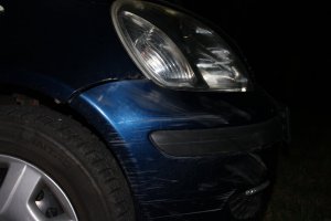 Zbliżenie na zarysowania przedniej prawej części niebieskiego samochodu