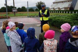 Policjant oraz grupa dzieci przed wyjściem w policyjny owocowy patrol