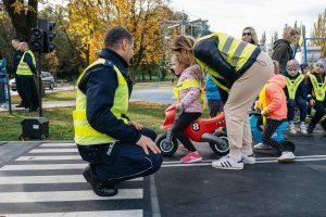 policjant w odblaskowej kamizelce z dziećmi