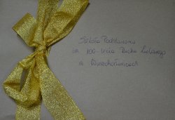 Szara koperta z żółta wstążką z napisem Szkoła Podstawowa w Wierzchosławicach