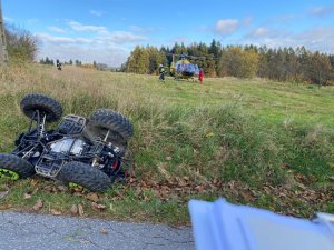 Quad leżący w rowie. Na pagórki stoi helikopter LPR-u gotowy do startu.