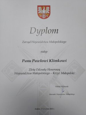 Dyplom nadania przez Zarząd Województwa Małopolskiego Złotej Odznaki Honorowej Krzyża Małopolski Pawłowi Klimkowi