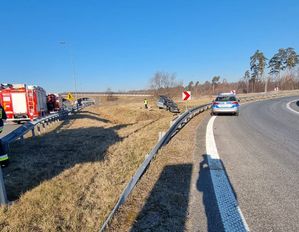 Miejsce wypadku, po lewej stronie wóz strażacki, po prawej stronie radiowóz, na środku, na pasie zieleni widać uszkodzony samochód osobowy, obok funkcjonariusz policji