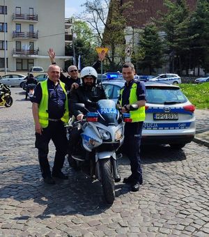 Umundurowani policjanci z policyjnym motocyklistą