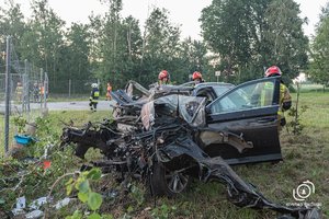 kompletnie zniszczony przód samochodu osobowego. W tle strażacy PSP