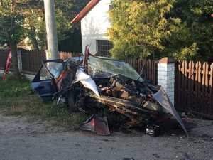 Kompletnie zniszczony samochód osobowy stojący przy posesji