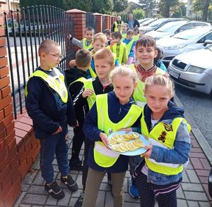 Dzieci w kamizelkach odblaskowych z przygotowanym plasterkami cytryny