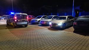 straż miejska z włączonymi światłami uprzywilejowania, na parkingu samochód z włączonymi światłami mijania.