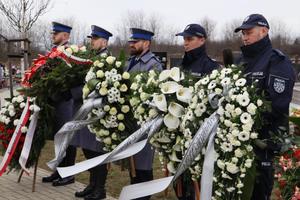 Policjanci trzymający wieńce