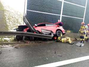 Zniszczony czerwony samochód przy barierach autostradowych. widok z boku.