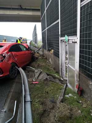 Zniszczony czerwony samochód przy barierach autostradowych. widok z tyłu.