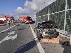 Widok uszkodzeń opla stojącego przy ekranach energochłonnych. Podniesiona pokrywa silnika zniszczony przód.