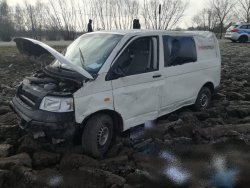 Rozbity dostawczy volkswagen w polu ornym. Widok z przodu z lewej strony, podniesiona pokrywa silnika