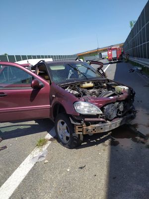 Uszkodzenia mercedesa stojącego na drodze przy ekranach dźwiękochłonnych