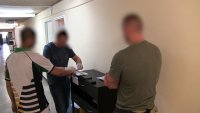 policjant nieumundurowany wykonuje daktyloskopię mężczyźnie na papier