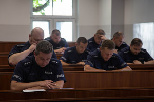 policjanci siedzący w ławkach