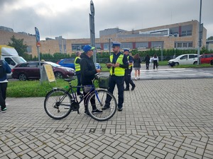 policjant ruchu drogowego przekazuje ulotkę rowerzyście