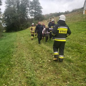 Grupa poszukiwawcza, policjant, strażacy i poszukiwana zaginiona