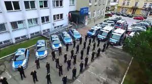 Policjanci w umundurowaniu służbowym ustawieni w rzędach na parkingu przed Komisariatem Policji Tarnów-Centrum